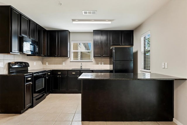 kitchen featuring sink, light tile patterned floors, decorative backsplash, and black appliances