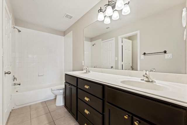 full bathroom featuring tile patterned flooring, vanity, tiled shower / bath combo, and toilet