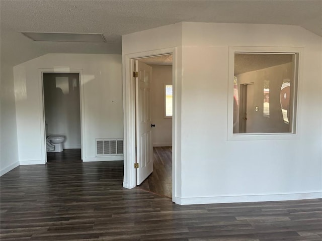 1207 NE Loop 230th Loop, Smithville, TX 78957 - corridor featuring dark wood-type flooring, lofted ceiling, baseboards, and a textured ceiling