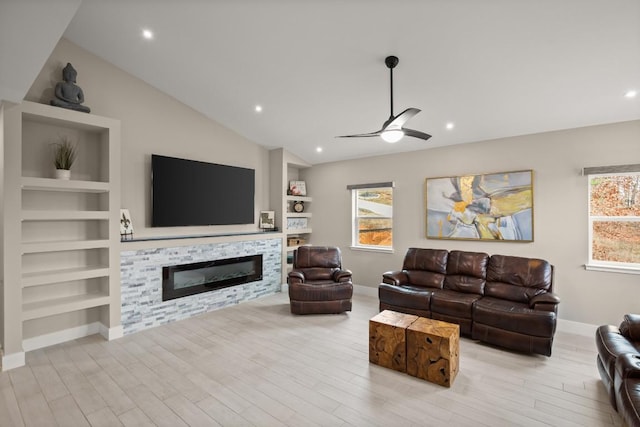 living room featuring ceiling fan, high vaulted ceiling, light hardwood / wood-style floors, and built in shelves