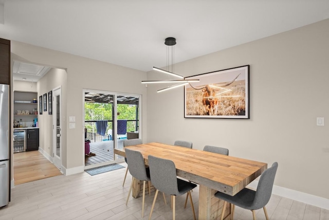 209 Kipahulu Dr, Bastrop, TX 78602 - dining room with beverage cooler, light wood-style flooring, a bar, and a chandelier