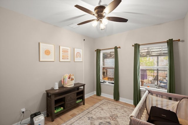 sitting room featuring baseboards, visible vents, a ceiling fan, and light wood-style floors