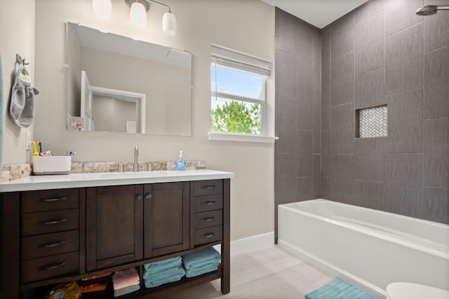 bathroom featuring shower / bathtub combination, vanity, and baseboards