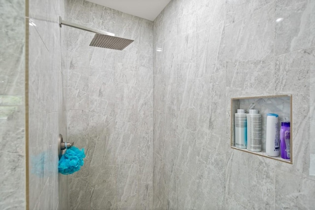 interior details featuring a tile shower