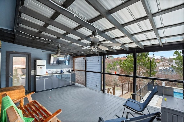 sunroom / solarium with ceiling fan, plenty of natural light, and sink