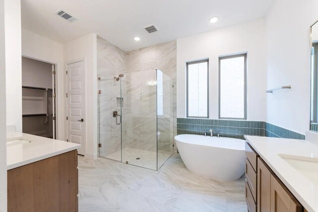 7605 Becasseau Dr, Austin, TX 78738 - bathroom featuring a freestanding bath, two vanities, a marble finish shower, and a spacious closet