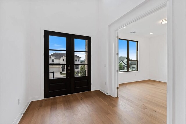 7605 Becasseau Dr, Austin, TX 78738 - entryway with wood finished floors, visible vents, french doors, and baseboards