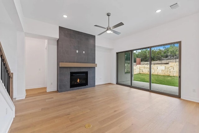 7605 Becasseau Dr, Austin, TX 78738 - unfurnished living room featuring visible vents, light wood-style flooring, a ceiling fan, baseboards, and a tiled fireplace