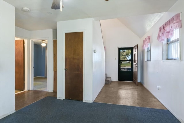 foyer with ceiling fan, a healthy amount of sunlight, dark parquet flooring, and vaulted ceiling