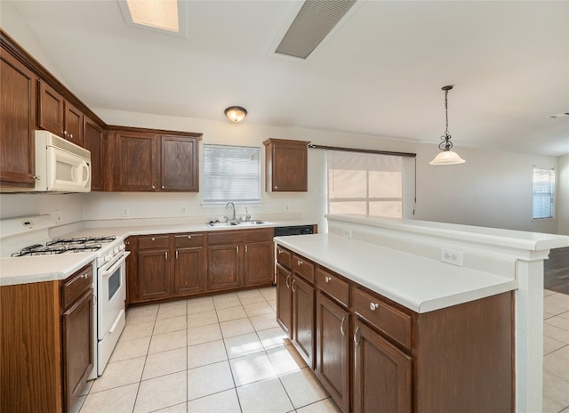 kitchen featuring sink, white appliances, decorative light fixtures, and light tile patterned flooring