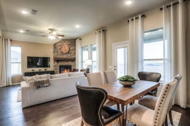 dining area with ceiling fan, dark hardwood / wood-style floors, and a fireplace