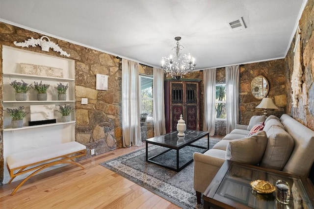 sitting room with crown molding, a chandelier, and hardwood / wood-style flooring