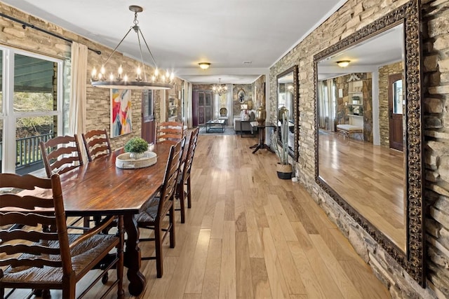 dining area featuring light hardwood / wood-style flooring and a notable chandelier