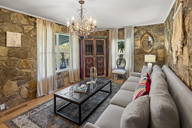 living room with hardwood / wood-style flooring, crown molding, and a chandelier