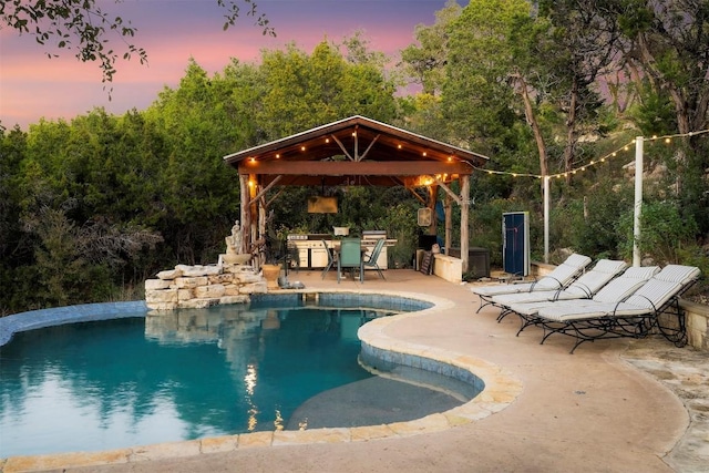 pool at dusk featuring a gazebo and a patio area