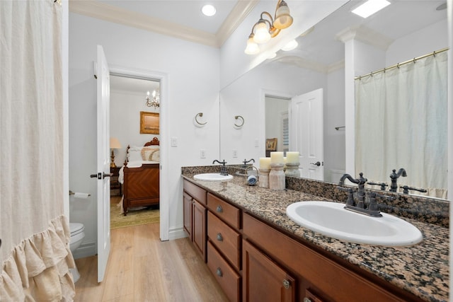 bathroom featuring vanity, hardwood / wood-style flooring, ornamental molding, and toilet