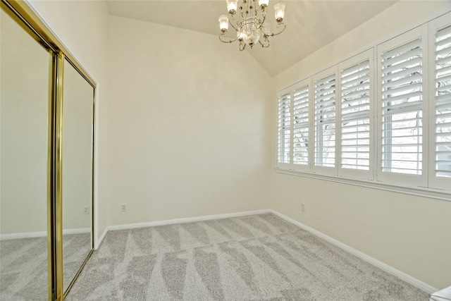 unfurnished bedroom featuring vaulted ceiling, light carpet, a notable chandelier, and a closet