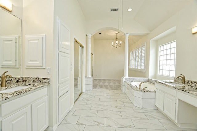 bathroom featuring vanity, lofted ceiling, tiled bath, and a chandelier