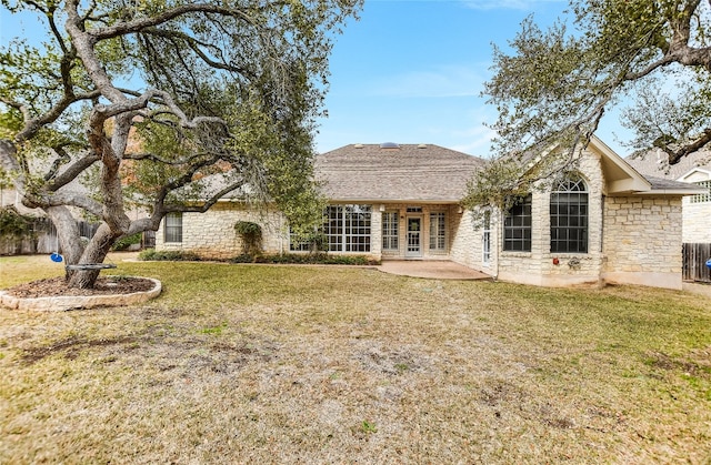 rear view of house with a patio and a lawn