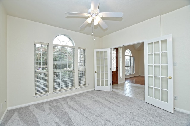 carpeted empty room with french doors and ceiling fan