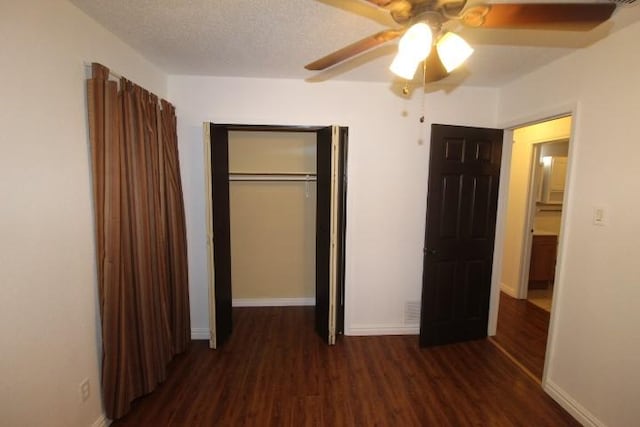 unfurnished bedroom featuring ceiling fan, dark hardwood / wood-style floors, a textured ceiling, and a closet