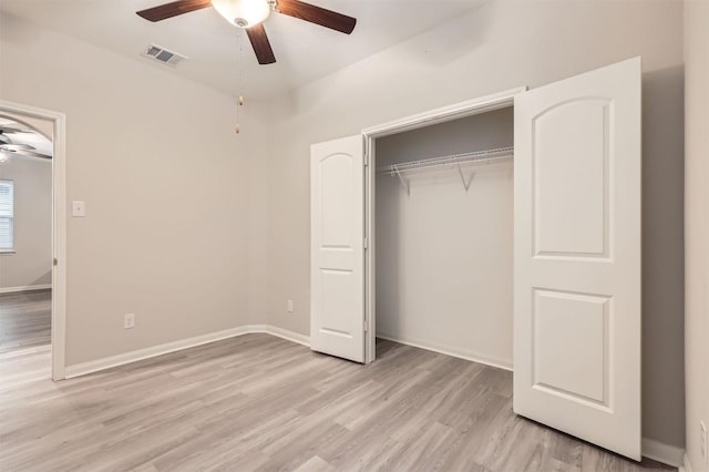 unfurnished bedroom with ceiling fan, light wood-type flooring, and a closet