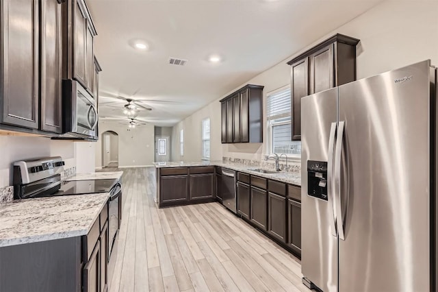 kitchen with sink, ceiling fan, kitchen peninsula, stainless steel appliances, and light hardwood / wood-style flooring