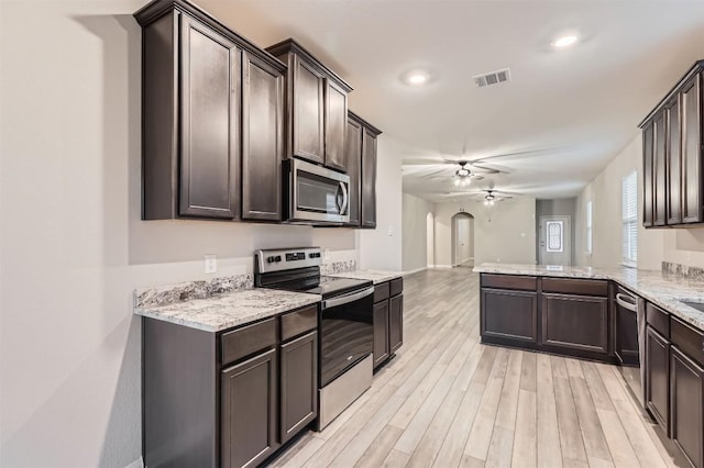 kitchen featuring appliances with stainless steel finishes, kitchen peninsula, dark brown cabinetry, ceiling fan, and light hardwood / wood-style floors