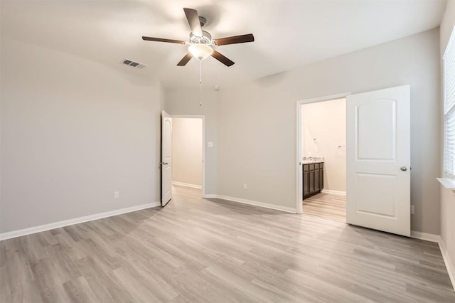 unfurnished bedroom with ceiling fan, light wood-type flooring, and ensuite bath