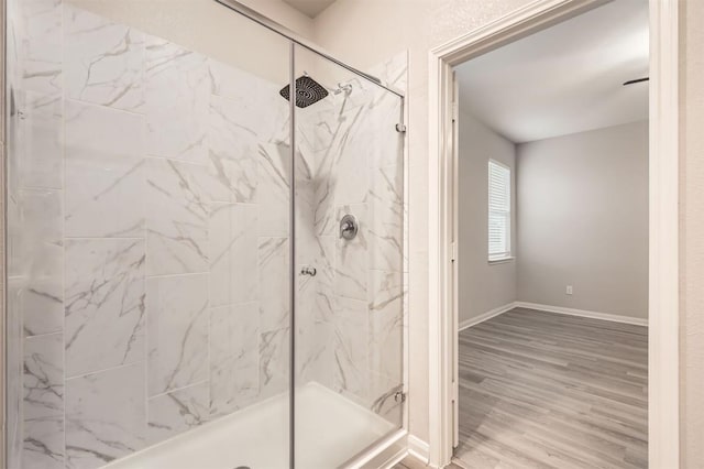 bathroom with hardwood / wood-style flooring and tiled shower