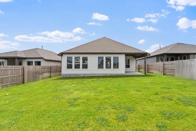 back of property with a lawn and a patio