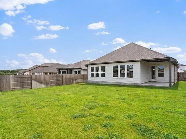 back of house featuring a lawn and a patio