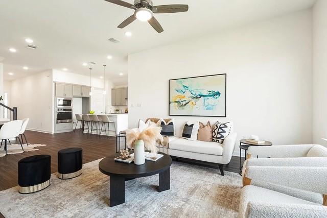 living room with wood-type flooring and ceiling fan