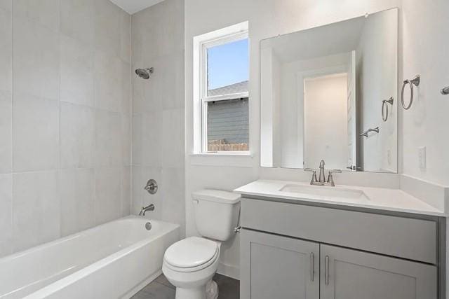 full bathroom featuring vanity, toilet, tiled shower / bath combo, and a wealth of natural light