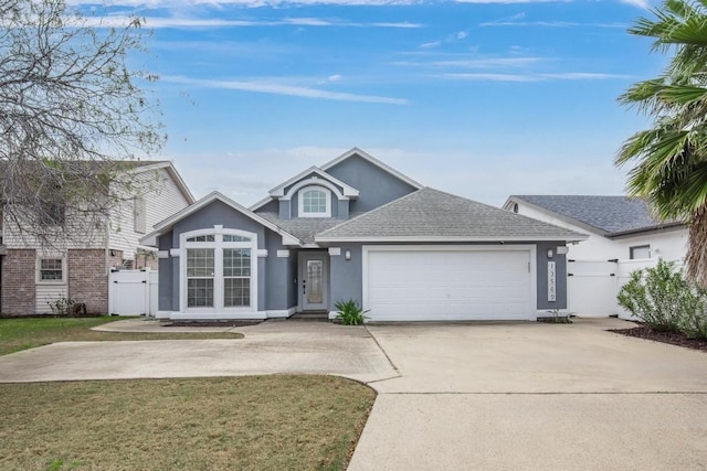 13569 Bullion Ct, Corpus Christi, TX 78418 - traditional-style home with stucco siding, roof with shingles, concrete driveway, and a gate