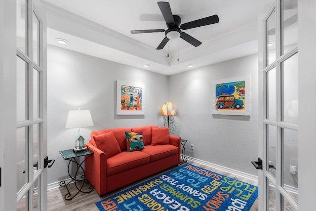 sitting room featuring crown molding, wood-type flooring, french doors, and ceiling fan