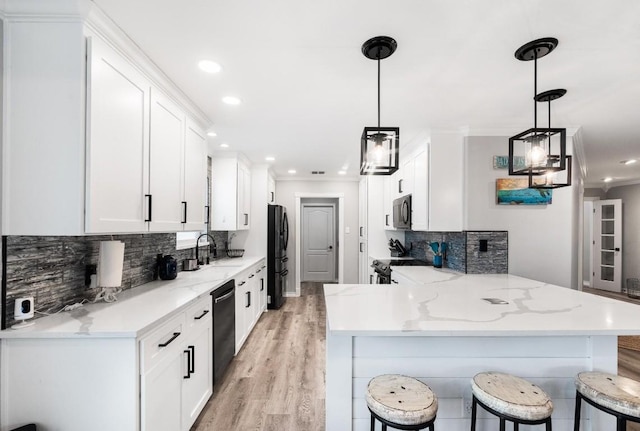 kitchen with white cabinetry, black appliances, kitchen peninsula, and a kitchen bar