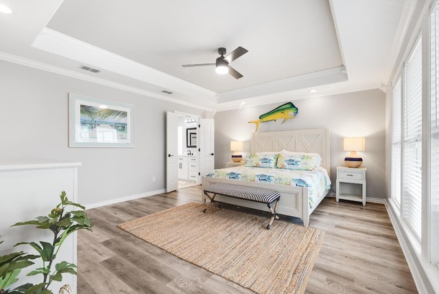 bedroom featuring a raised ceiling, ornamental molding, ceiling fan, and light hardwood / wood-style flooring