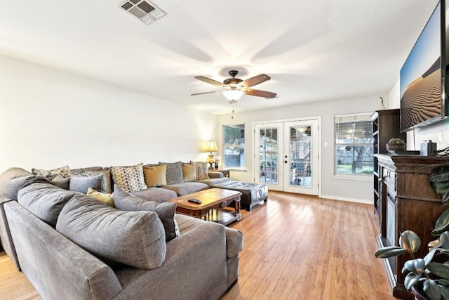 living room featuring ceiling fan, light hardwood / wood-style floors, and french doors