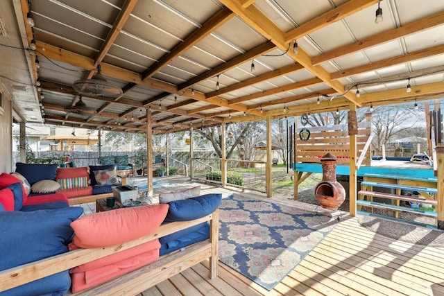 wooden deck featuring an outdoor hangout area, a patio area, and fence