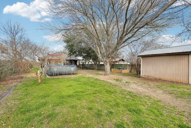 view of yard with a fenced in pool, fence, and an outdoor structure