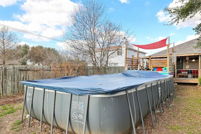 exterior space featuring a fenced in pool, a fenced backyard, and a deck