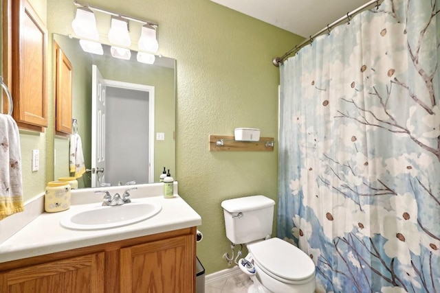 bathroom featuring a textured wall, curtained shower, vanity, and toilet