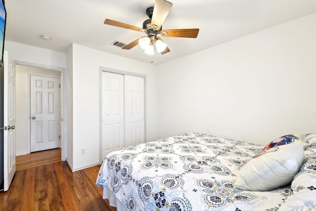 bedroom featuring a closet, visible vents, ceiling fan, wood finished floors, and baseboards