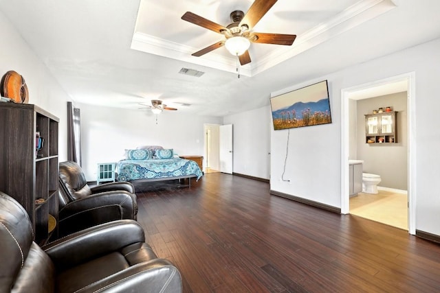 living area with visible vents, a raised ceiling, ceiling fan, ornamental molding, and dark wood-type flooring