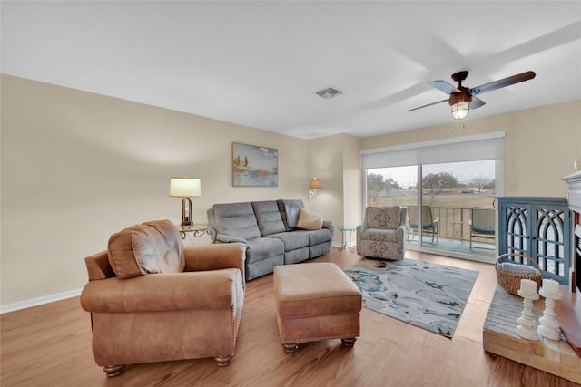 living room with light hardwood / wood-style floors and ceiling fan