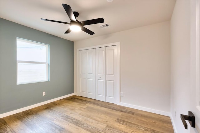 unfurnished bedroom with light hardwood / wood-style floors, a closet, and ceiling fan