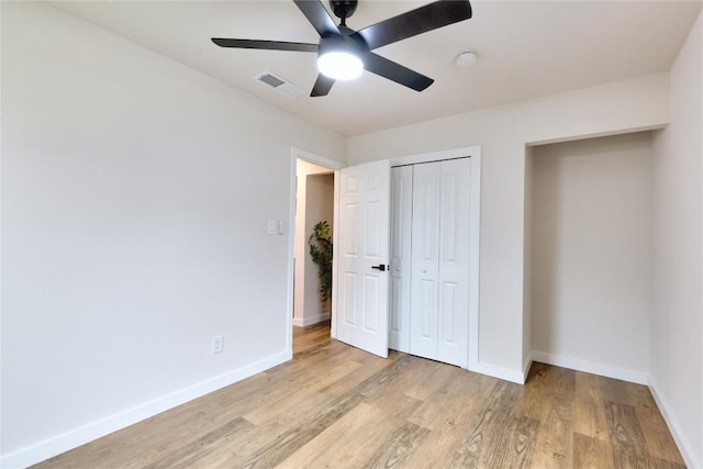 unfurnished bedroom featuring ceiling fan, light hardwood / wood-style floors, and a closet