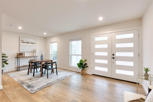 dining space with light wood-type flooring and french doors