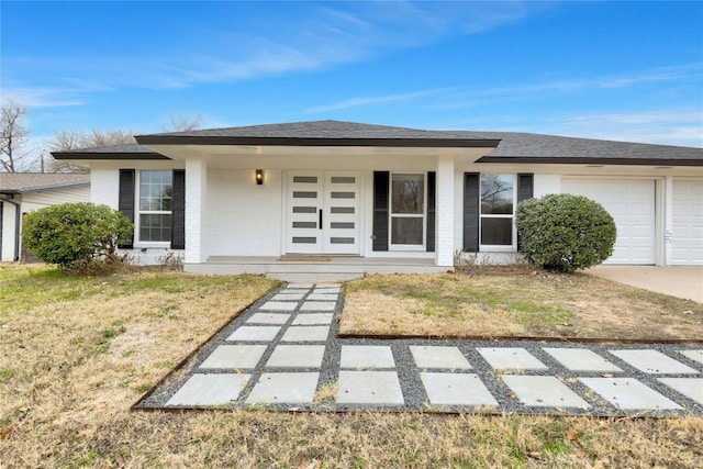 view of front of house with a garage, covered porch, and a front lawn